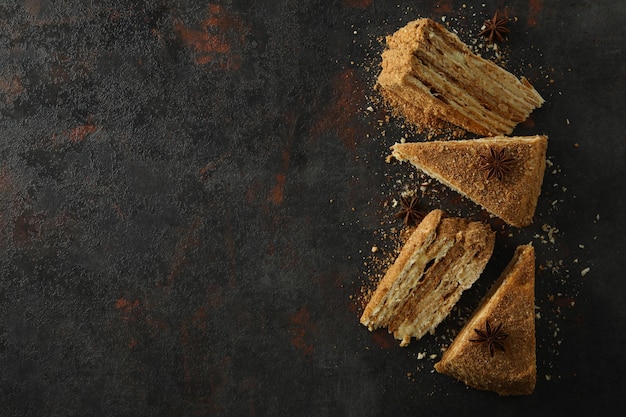 Photo pieces of honey cake on dark textured background