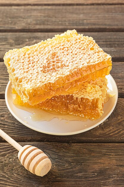 Pieces of honeycomb on a plate and a honey spoon