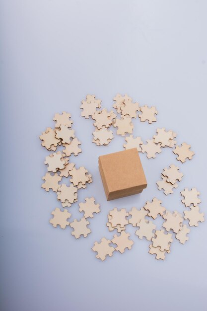 Pieces of jigsaw puzzle around box as problem solution concept
