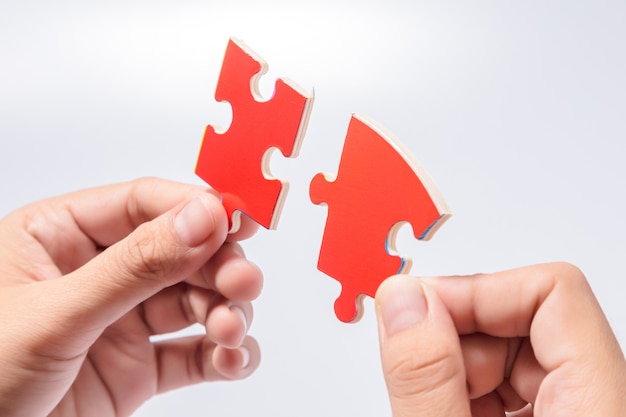 Pieces of jigsaw puzzle in woman's hands