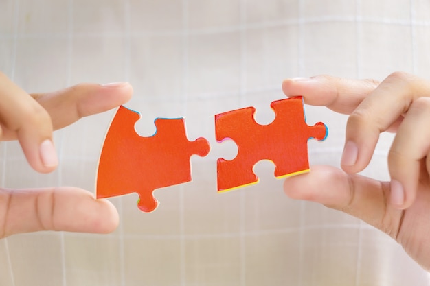 Pieces of jigsaw puzzle in woman's hands