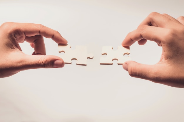 Pieces of jigsaw puzzle in woman's hands