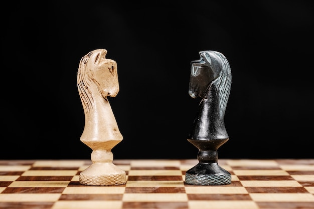 Pieces of knights facing each other on a chessboard