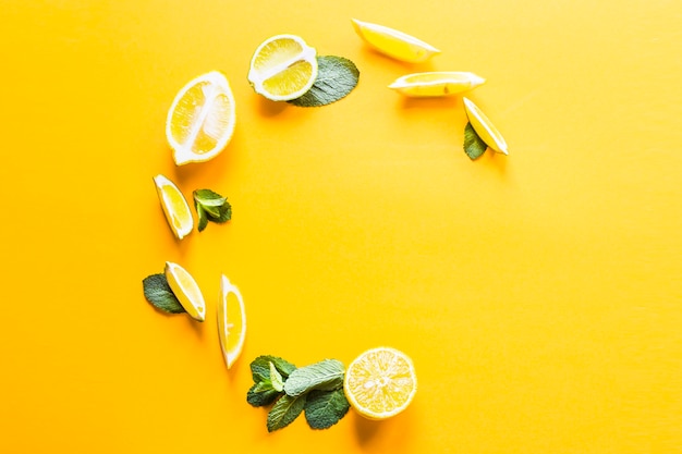 Photo pieces of lemon, lime and green mint leaves lined in a circle