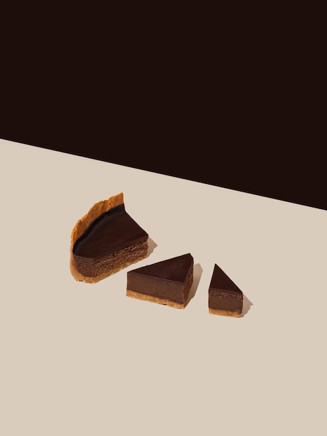사진 베이지색과 갈색 배경에 있는 다크 초콜릿 치즈 케이크 조각, 미니멀한 음식 사진