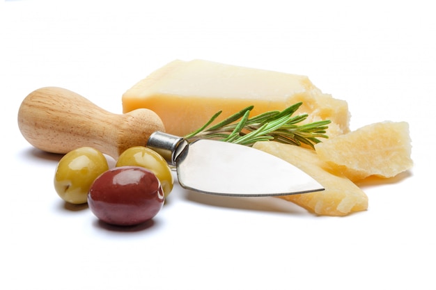Кусочки сыра пармезан и нож на белом столе