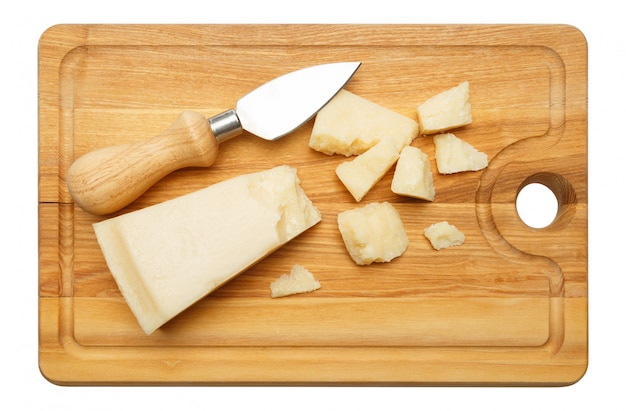 Photo pieces of parmesan cheese on wooden cutting board