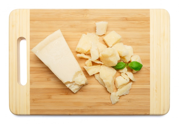 Pieces of Parmesan cheese on wooden cutting board