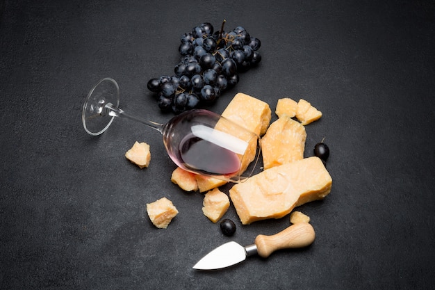 Foto pezzi di parmigiano o parmigiano, vino e uva