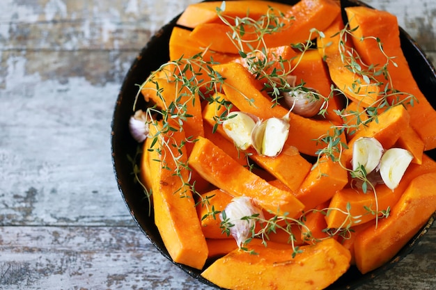 Pieces of pumpkin in a skillet before baking.