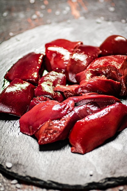 Pieces of raw liver on a stone tray with salt