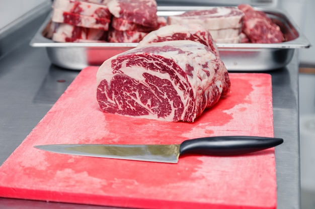 Pieces of ribeye marbled beef steak and knife