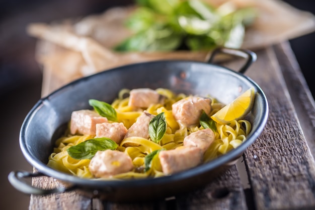 Pieces of salmon with pasta tagliatelle lemon and basil.