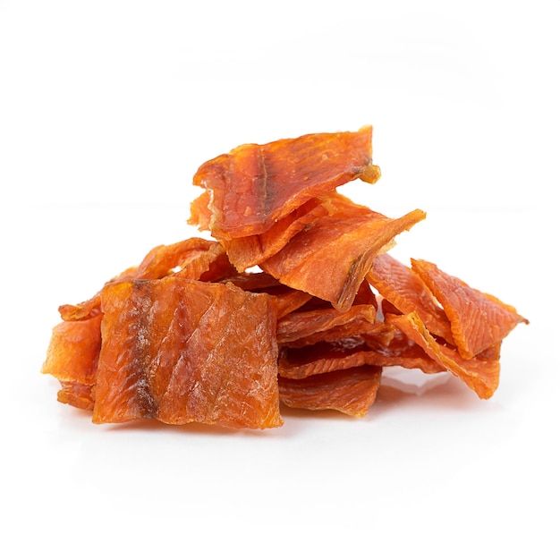 Pieces of salted dried fish with spices on a white background an appetizer for beer