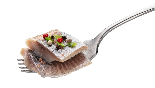 Pieces of salted herring on fork isolated on white background with clipping path, slices of marinated mackerel fish fillet