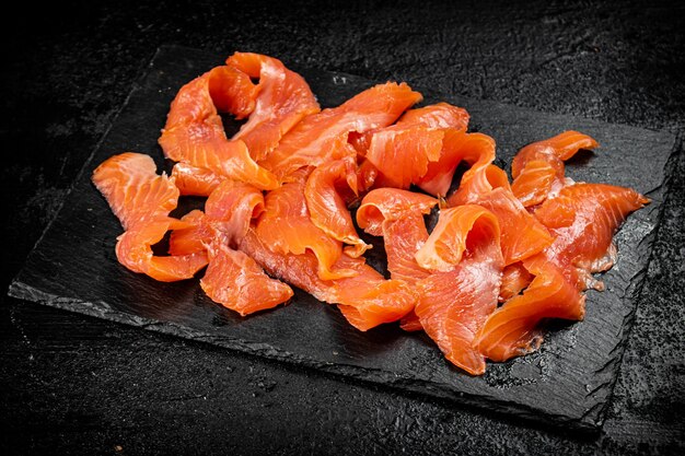 Pieces of salted salmon on a stone board