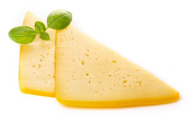 Pieces of semi-hard or hard yellow cheese with holes and basil leaf isolated on a white background.