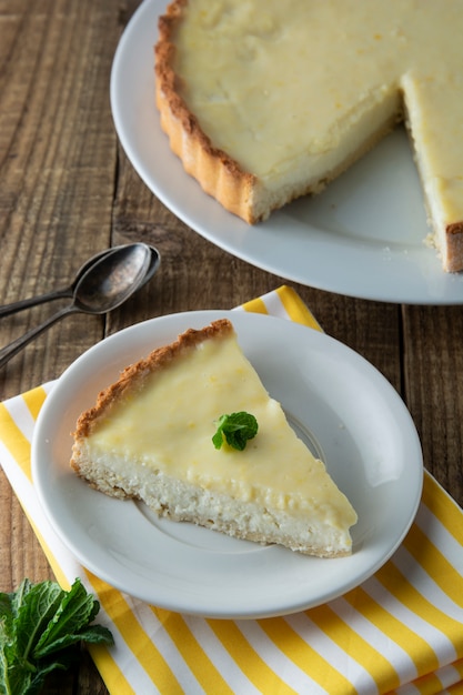 Pieces, slices of delicious homemade lemon cheesecake on plate with mint. Dessert.