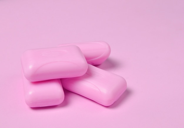 Pieces of soap close-up on a pink pastel background