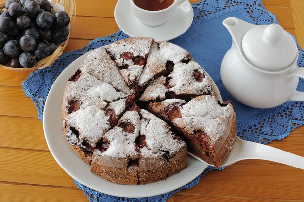 Pieces of sponge cake with plum and a cup of tea