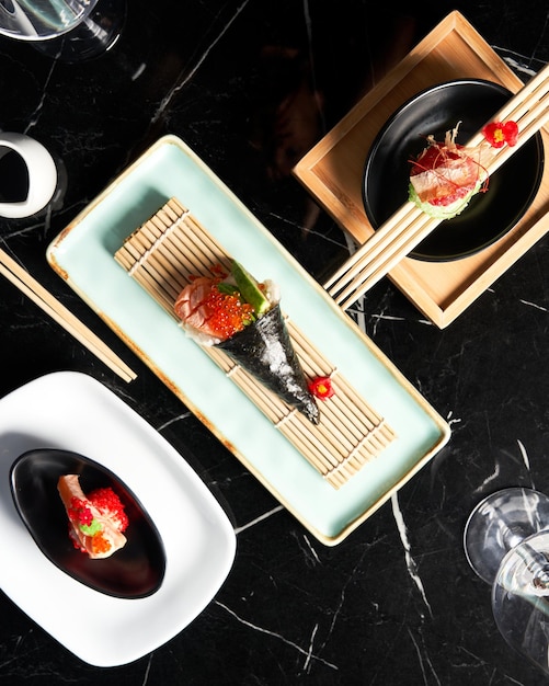 Foto pezzi di sushi serviti con un vasetto di salsa di soia al ristorante vista piatta concetto di cibo