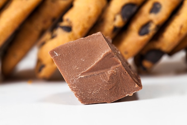 Pieces of sweet chocolate together with cookies with pieces of chocolate inside as a filling