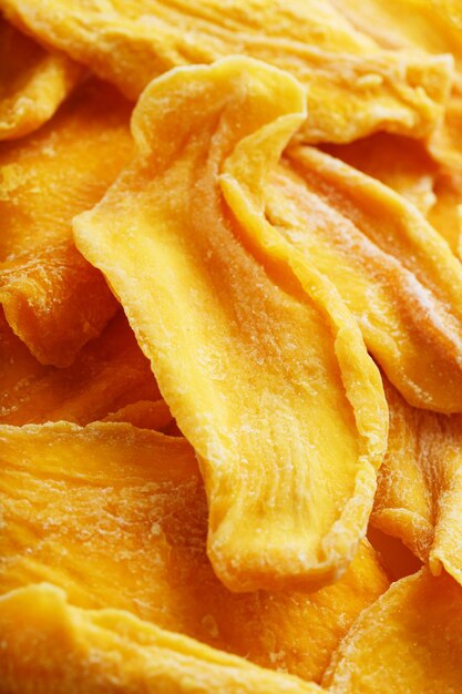 Pieces of sweet dried mango closeup as a background in full screen