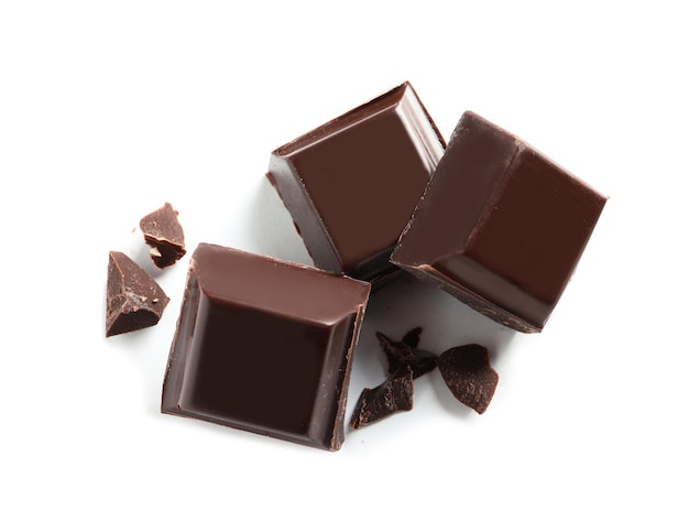 Pieces of tasty dark chocolate on white background top view