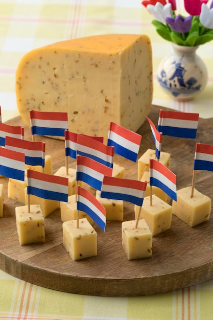 Pieces of traditional Dutch cumin cheese with Dutch red white and blue paper flag