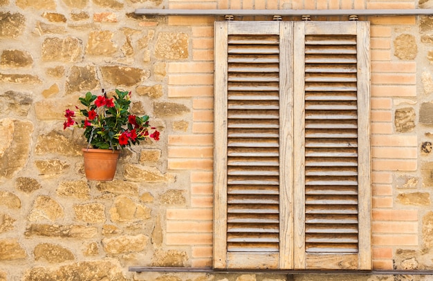 Pienza, regio Toscane, Italië. Oud raam met bloemen