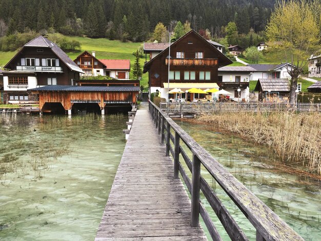 pier amidst lake leading towards houses