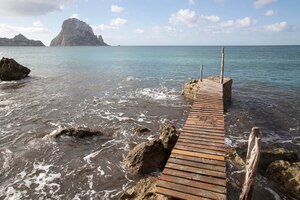 pier and island at cala hort cove in ibiza, spain