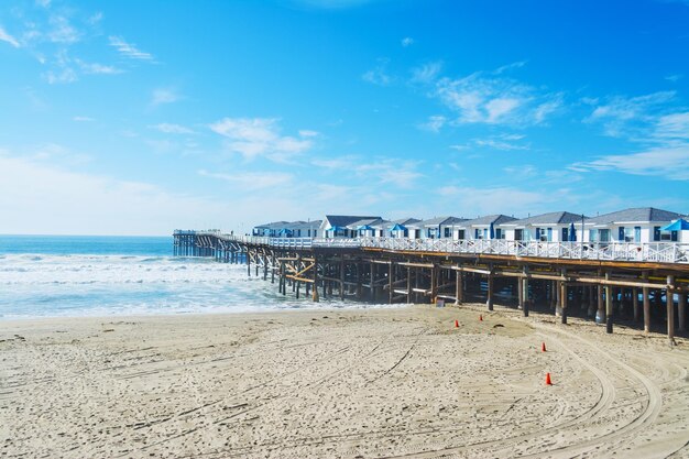 Photo pier on beach against blue sky