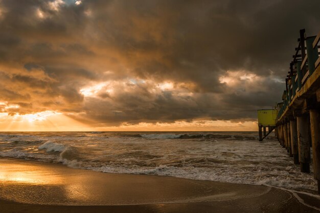 Pier in a beach during a sunrise