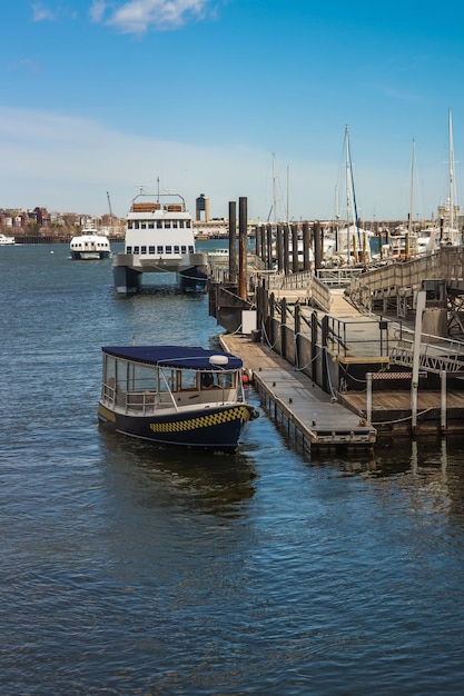 Pier of Boston Wharf with sail boat and Charles River,  Boston, Massachusetts, the United States. People on the background