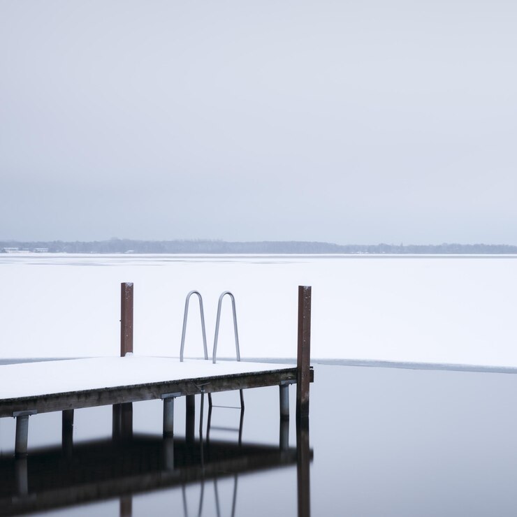 Photo pier by frozen lake against sky
