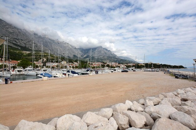 Photo pier at harbor in baska voda against cloudy sky