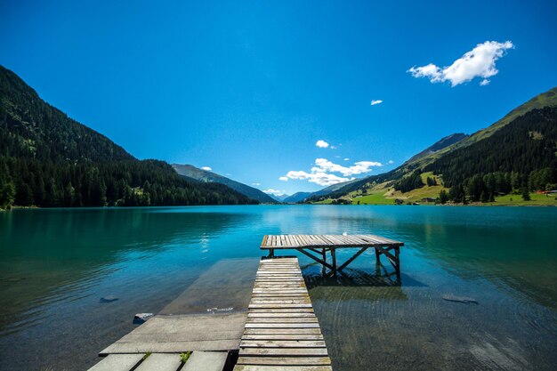 Photo pier over lake against blue sky