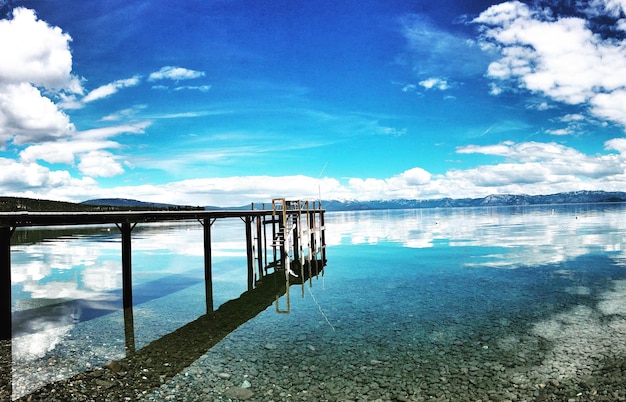 Pier over lake against blue sky