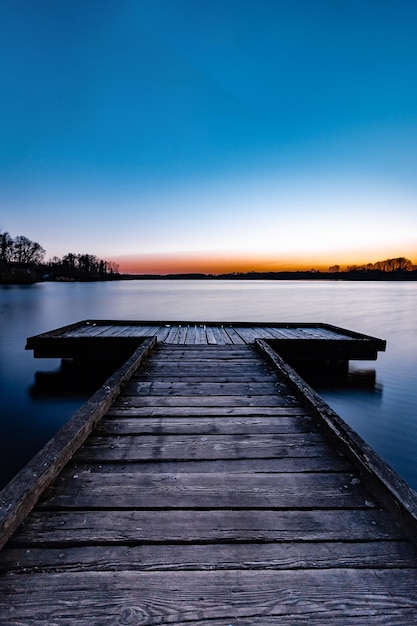 Photo pier over lake against clear blue sky