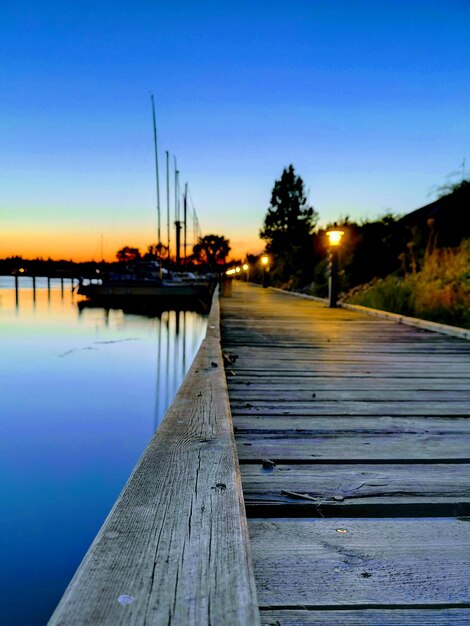 Photo pier over lake against clear sky at sunset