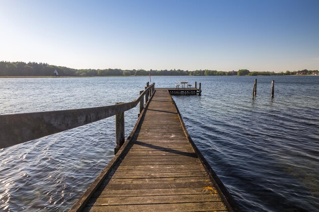 Photo pier over lake against clear sky