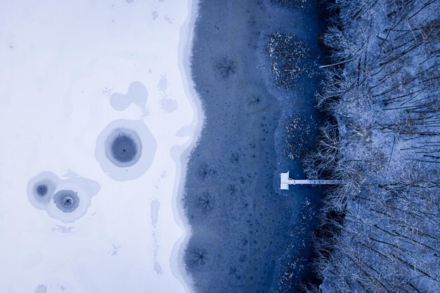 冬のポーランドでの釣りのための桟橋の湖と氷の穴