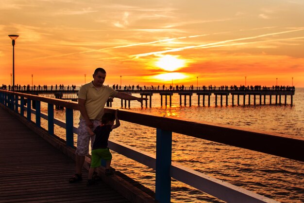 Pier op de zee zonsondergang Palanga vader en zoon wandelen langs de waterkant