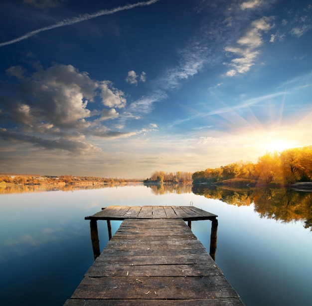 Pier op een kalme rivier in de herfst