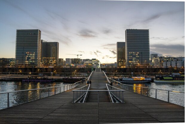 Pier over de rivier door gebouwen tegen de lucht in de stad