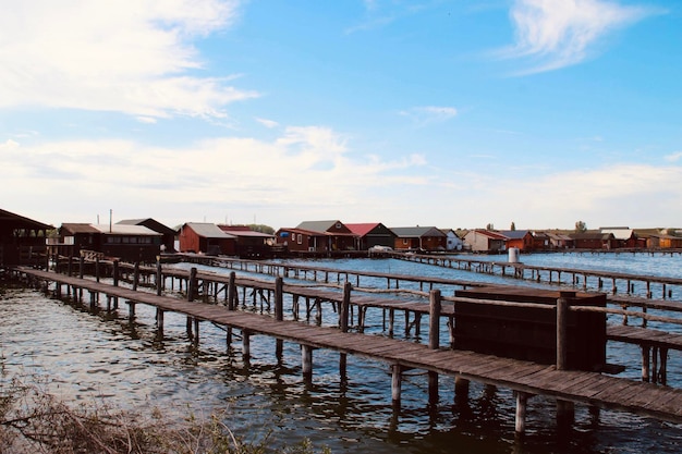 Foto pier over de rivier door huizen tegen de lucht