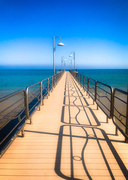 Pier over de zee tegen de blauwe hemel