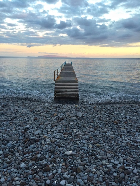Pier over de zee tegen de hemel tijdens zonsondergang