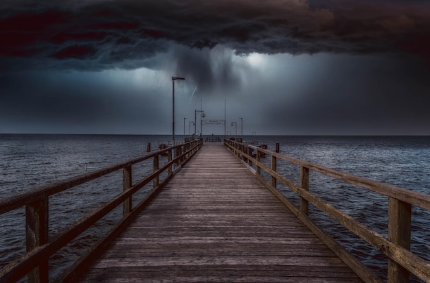 Pier over zee tegen stormwolken